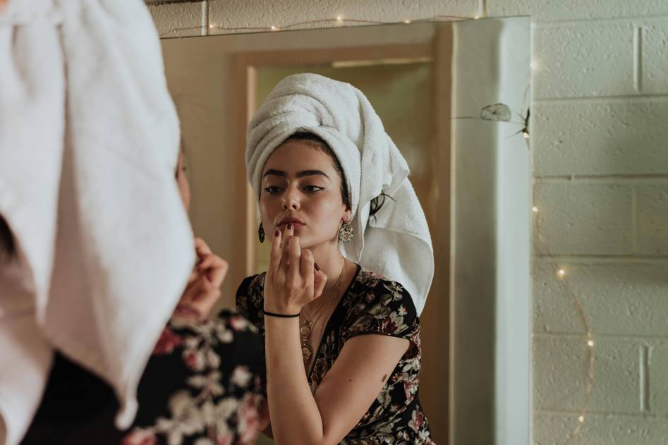 Woman applying natural oil in soft morning light